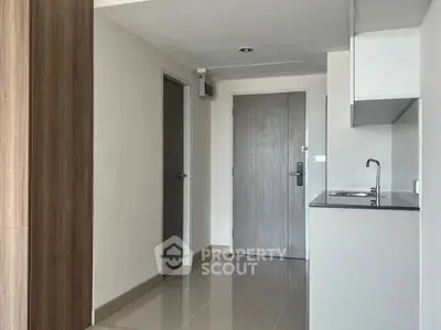 Modern apartment entrance with sleek kitchenette and minimalist design