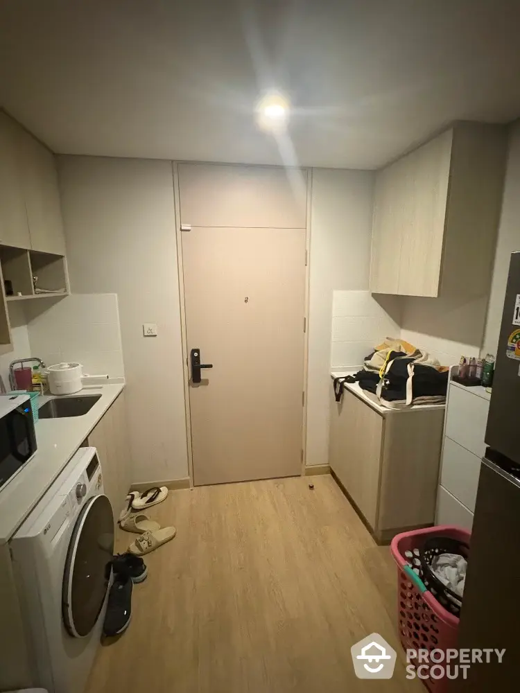 Compact kitchen with washing machine and modern cabinetry