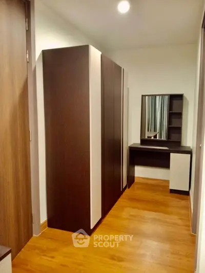 Modern bedroom with sleek wardrobe and stylish vanity in a cozy apartment.