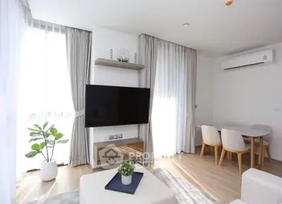 Modern living room with large TV, dining area, and natural light