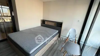 Modern bedroom with glass table and city view, perfect for urban living.