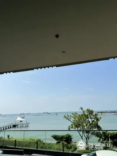 Stunning waterfront view from a modern balcony with lush greenery and serene ocean scenery.