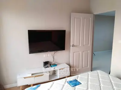 Modern bedroom with wall-mounted TV and stylish furniture