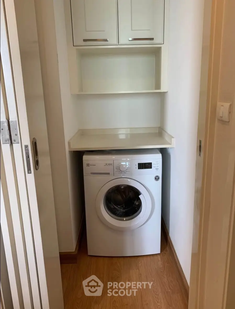 Compact laundry nook with washing machine and storage shelves