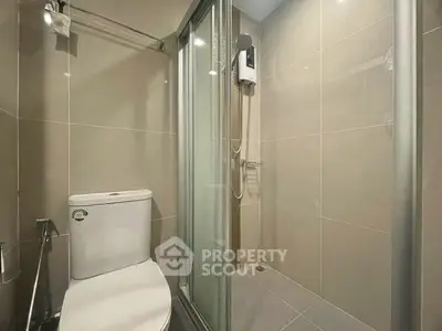 Modern bathroom with sleek shower and toilet in contemporary apartment.