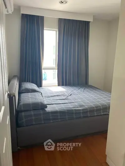 Cozy bedroom with large window and stylish curtains, perfect for natural light lovers.