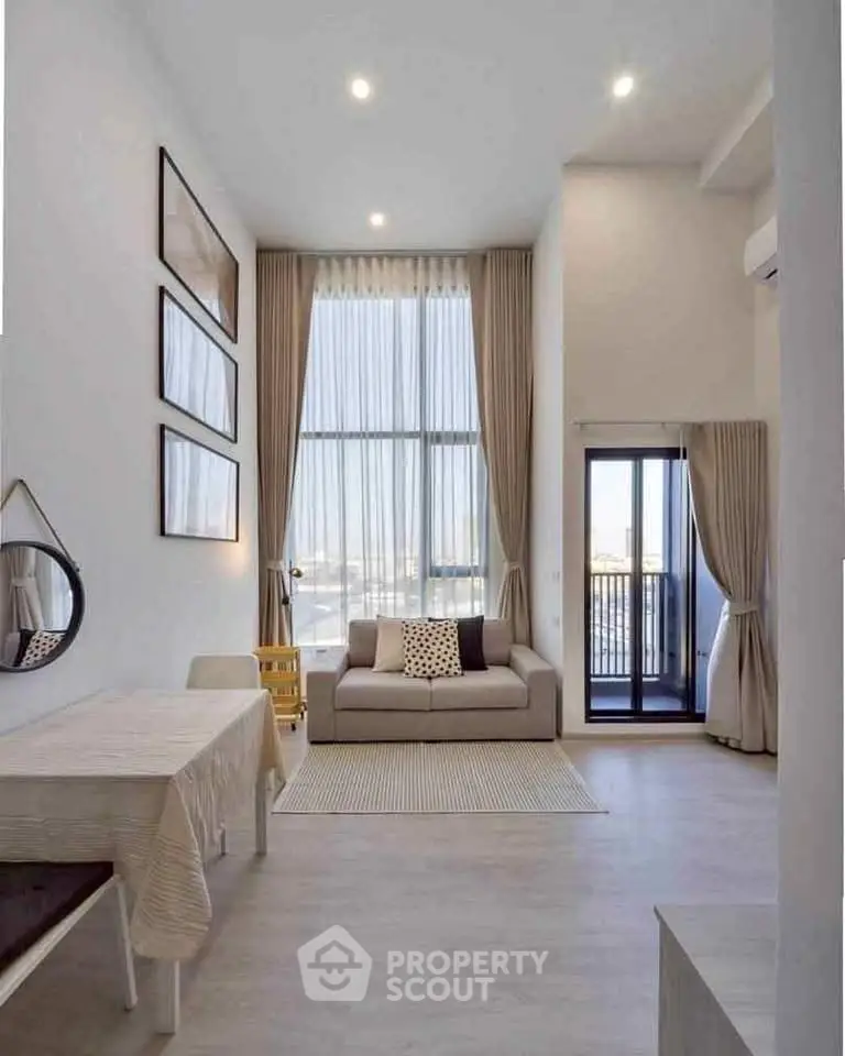 Modern living room with high ceilings, large windows, and elegant decor in a stylish apartment.