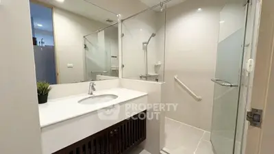 Modern bathroom with glass shower and sleek vanity in a contemporary home.