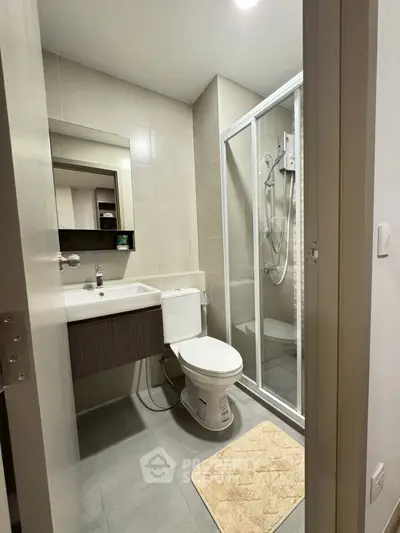 Modern bathroom with shower and sleek fixtures in contemporary apartment.