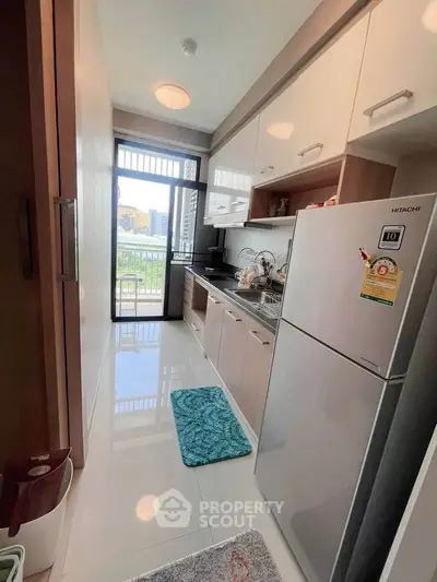Modern kitchen with sleek cabinets and large fridge in a compact layout