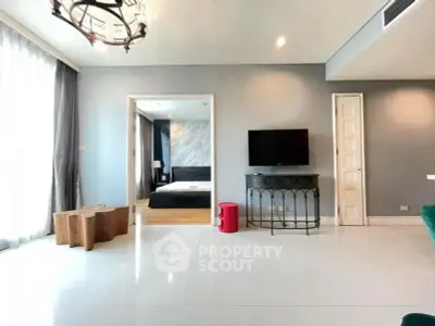 Spacious modern living room with open view to elegant bedroom, featuring stylish decor and natural light.