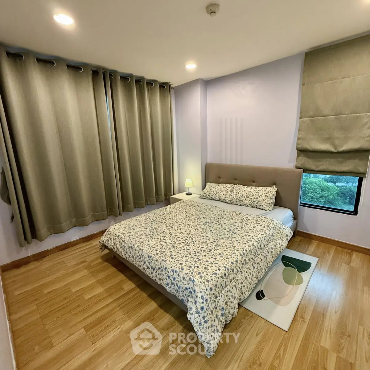 Cozy bedroom with wooden flooring and elegant curtains in modern apartment