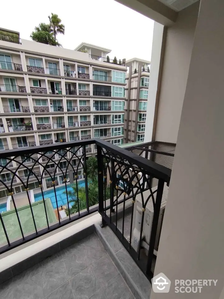 Modern apartment balcony with pool view in urban setting