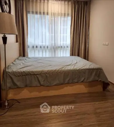 Cozy bedroom with large window and elegant curtains, perfect for relaxation and comfort.