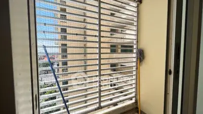 Enclosed balcony with safety netting and partial city view, ideal for secure outdoor space.