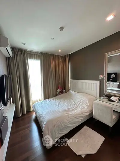 Cozy bedroom with elegant decor and natural light, featuring a plush bed and stylish furnishings.