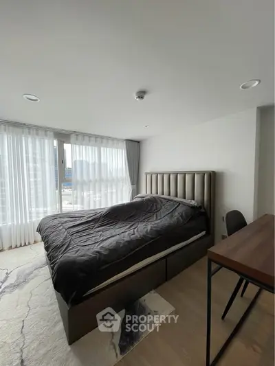Modern bedroom with large window and stylish decor in high-rise apartment