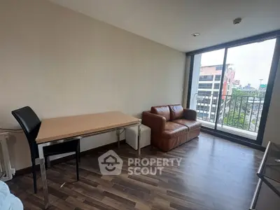 Modern living room with city view, featuring a cozy leather sofa and sleek dining table, perfect for urban living.