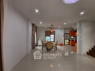 Spacious open-plan dining area with modern kitchen and elegant lighting.