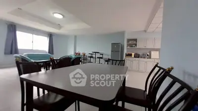 Spacious open-plan living room with modern kitchen and dining area, featuring natural light and stylish furnishings.