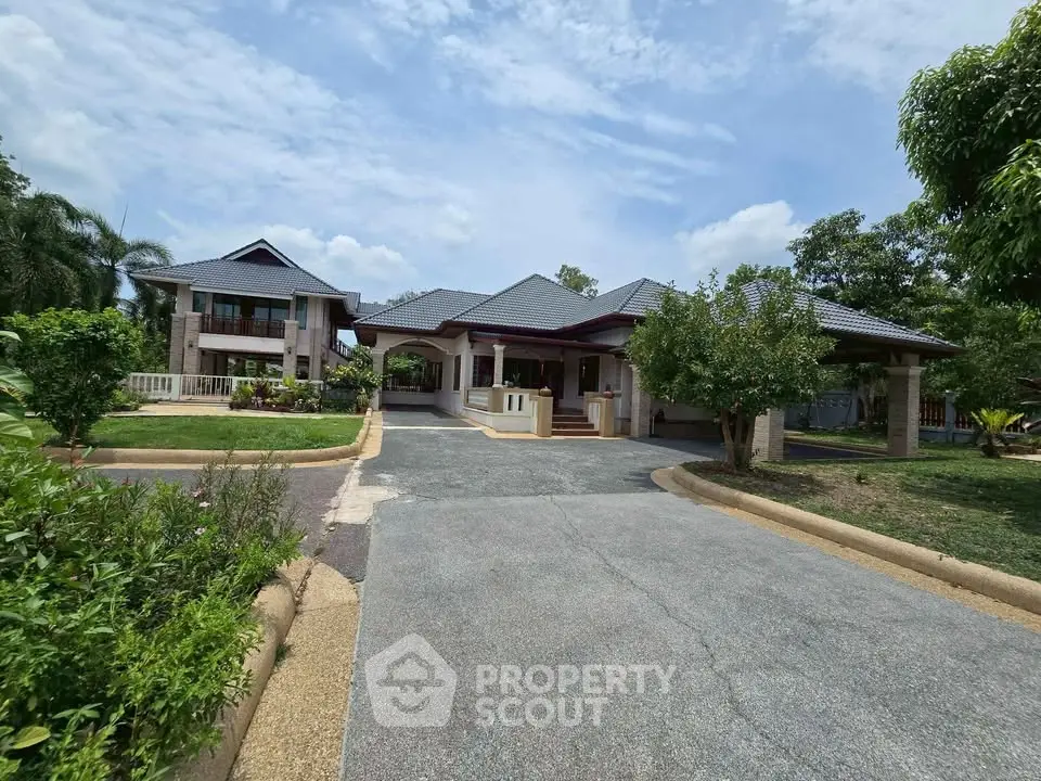 Stunning luxury home with spacious driveway and lush greenery, perfect for serene living.