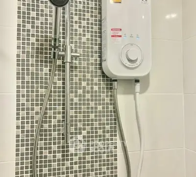 Modern bathroom with sleek shower and water heater installation.