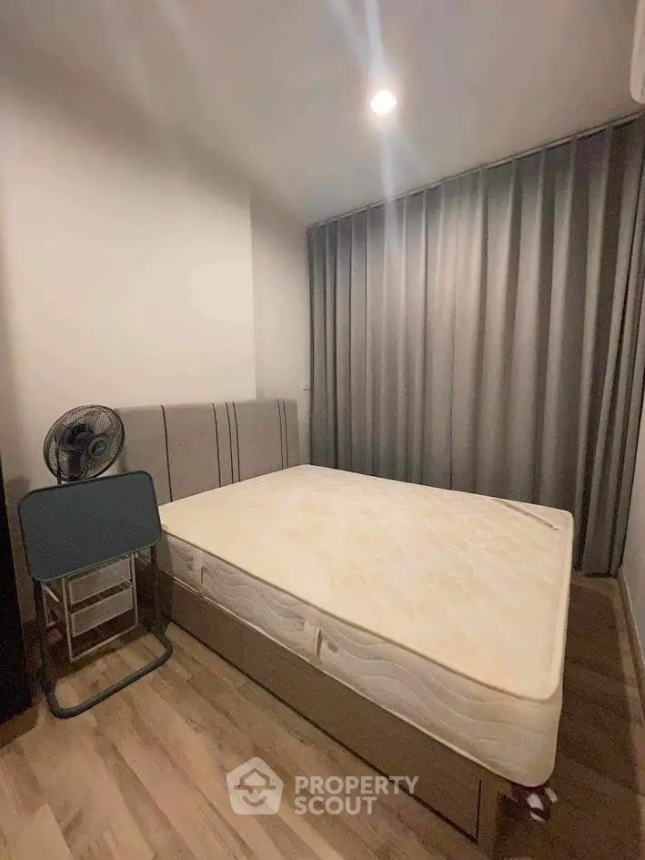 Cozy bedroom with modern design, featuring a comfortable bed and sleek wooden flooring.