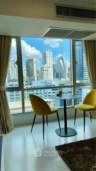Stunning city view from modern apartment with stylish seating area.