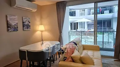 Modern living room with cozy sofa, dining table, and large window overlooking a stylish courtyard.