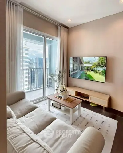 Modern living room with large TV and balcony view in high-rise apartment