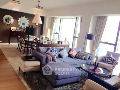 Spacious modern living room with stylish decor and large windows offering natural light.