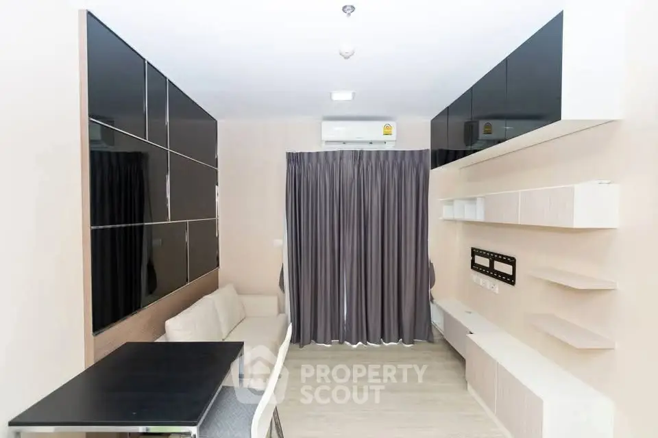 Modern living room with sleek black cabinets and cozy white sofa