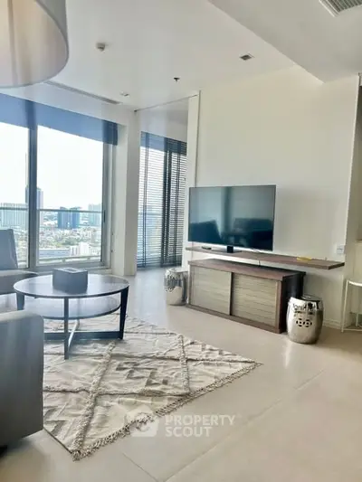 Modern living room with city view, stylish furniture, and large TV setup.