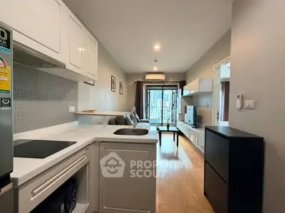 Modern open-layout kitchen and living room with balcony view in urban apartment.