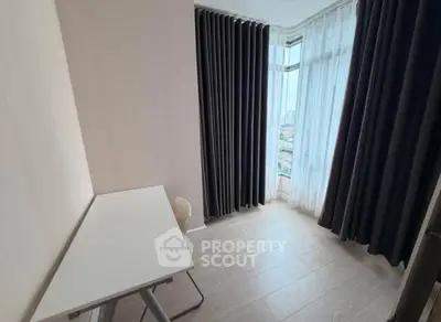 Bright study room with large windows and modern curtains, perfect for productivity.