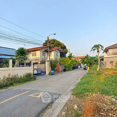 Charming suburban street view with houses and lush greenery, perfect for family living.