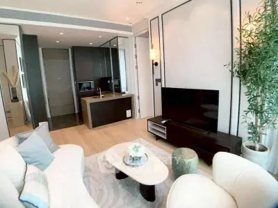 Modern living room with sleek design, featuring a cozy seating area, stylish TV unit, and open kitchen layout.