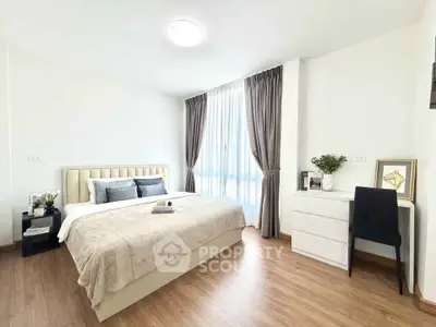 Spacious bedroom with elegant decor and natural light in modern apartment.