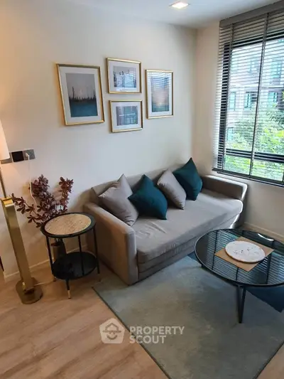 Chic living room with modern decor, cozy sofa, and large window offering natural light and garden view.