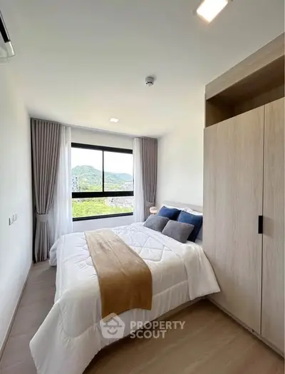 Modern bedroom with scenic view, featuring cozy bed and sleek wardrobe.