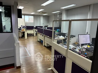 Modern office space with wooden flooring and partitioned workstations