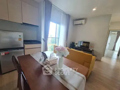Modern living room with dining area, featuring stylish furniture and natural light.