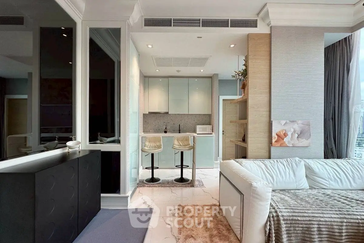 Modern open-plan living room with sleek kitchen and cozy seating area in luxury apartment.