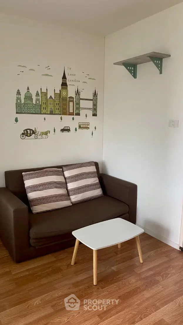 Cozy living room with brown sofa, wall art, and wooden floor