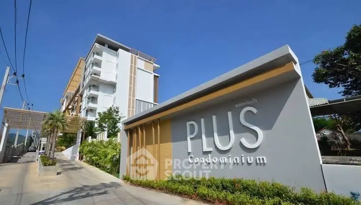 Modern condominium building with stylish exterior and lush greenery.