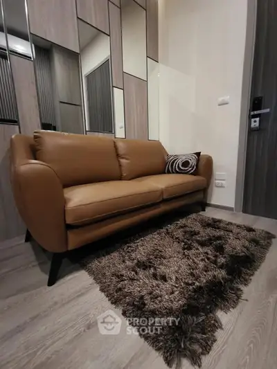 Stylish modern living room with brown leather sofa and plush rug