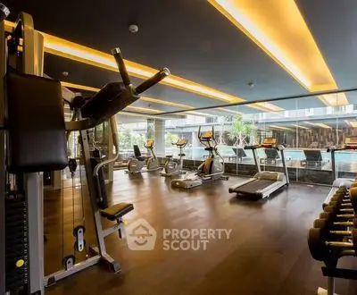 Luxurious gym with modern equipment and pool view in upscale residential building.