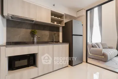 Modern kitchen with sleek appliances and open layout leading to cozy living area.