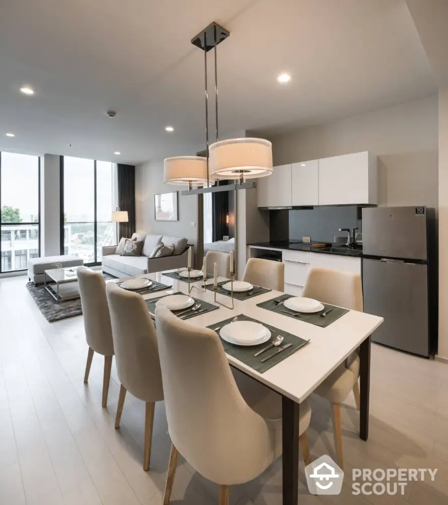 Modern open-plan living room and kitchen with elegant dining area and stylish decor.