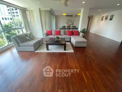 Spacious living room with hardwood floors and large windows in modern apartment